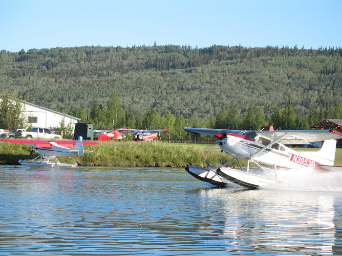 A small pontoon airplane taking off at Chena Marina