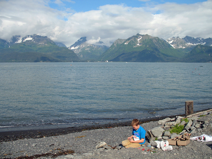 Karl plays with his cars by the shore of our campsite