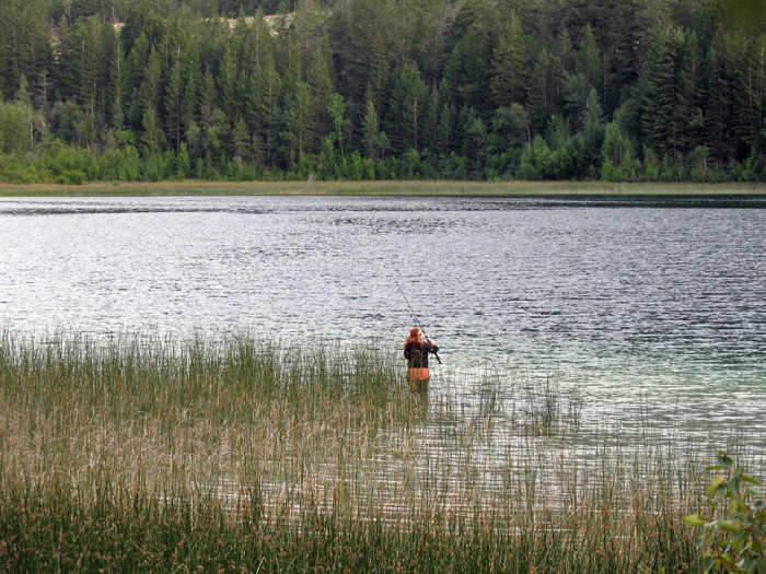 Isabella tries her luck fishing in the little lake below the trailer