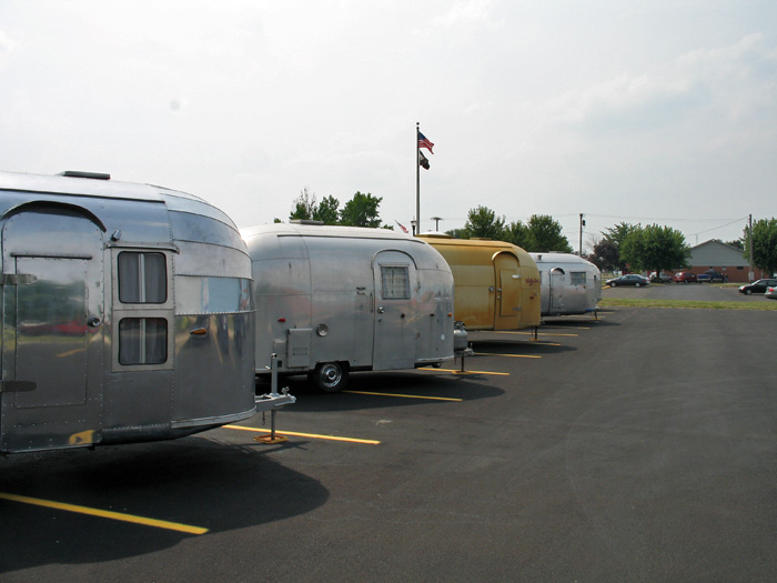 Several vintage Airstreams parked in front of the Airstream factory