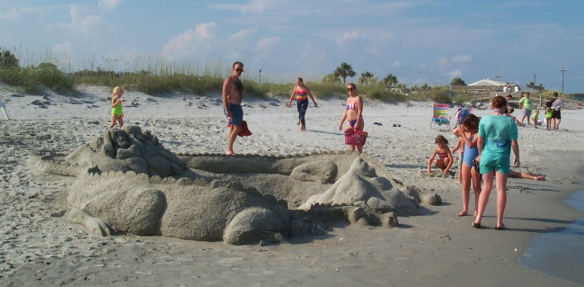 A large sand sculpture on the beach